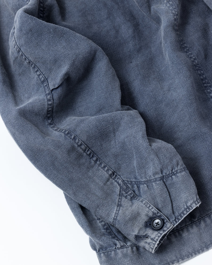 利便性の高い多機能ポケットを備えた、フレンチリネンのユーティリティジャケット。肉厚ながら「とろみ」のある柔らかなフレンチリネンを採用し、清涼感のある着心地を実現しました。硫化染め後に水を使用しないサスティナブルブリーチ加工を施すことで、環境に配慮しながらも、長年着込んだような深みのある色褪せとヴィンテージライクな佇まいを表現しています。

A utility jacket featuring functional pockets and a relaxed silhouette. Crafted from thick yet supple French Linen for a cool, soft touch. This NAVY piece undergoes a sulfur-dye and waterless sustainable bleach process, authentically recreating a deep, sun-faded vintage character while staying eco-conscious.