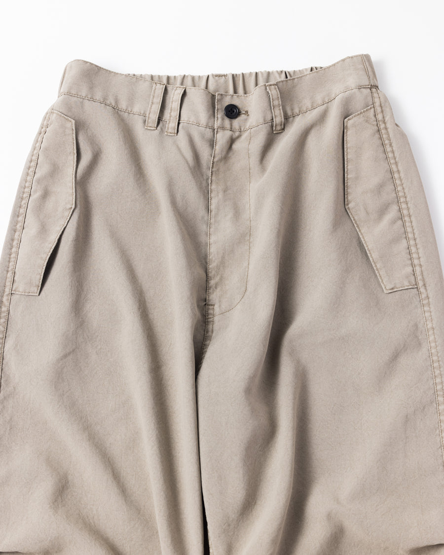 ポリエステル100％ながら、綿のような質感と軽量性を備えた高機能素材を採用。タスラン加工糸によるポリエステルオックスは、シワになりにくく速乾性にも優れています。染色が困難なポリエステルに特殊顔料染めを施すことで、化繊特有の光沢を抑え、ナチュラルで奥行きのある絶妙なフェード感と落ち着いた表情を実現しました。

High-performance polyester oxford with a cotton-like touch, offering quick-dry and wrinkle-resistant benefits. This GRAY BEIGE item features a special pigment dye—a rare process for polyester—achieving a sophisticated, faded texture and a matte finish that perfectly balances technical utility with a natural, lived-in aesthetic.