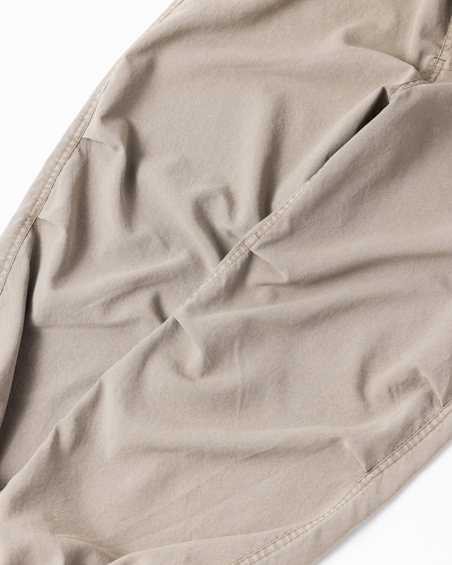 ポリエステル100％ながら、綿のような質感と軽量性を備えた高機能素材を採用。タスラン加工糸によるポリエステルオックスは、シワになりにくく速乾性にも優れています。染色が困難なポリエステルに特殊顔料染めを施すことで、化繊特有の光沢を抑え、ナチュラルで奥行きのある絶妙なフェード感と落ち着いた表情を実現しました。

High-performance polyester oxford with a cotton-like touch, offering quick-dry and wrinkle-resistant benefits. This GRAY BEIGE item features a special pigment dye—a rare process for polyester—achieving a sophisticated, faded texture and a matte finish that perfectly balances technical utility with a natural, lived-in aesthetic.