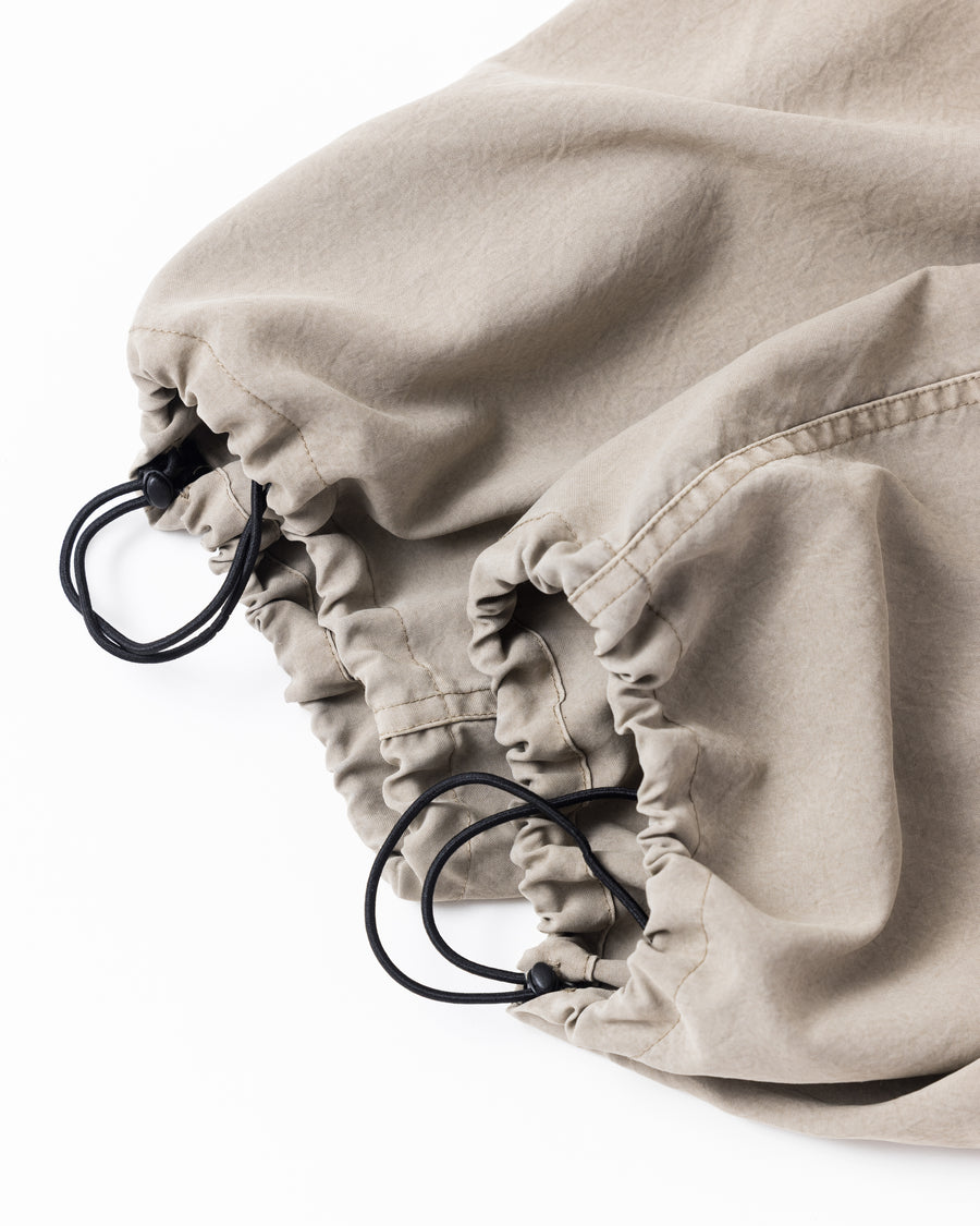 ポリエステル100％ながら、綿のような質感と軽量性を備えた高機能素材を採用。タスラン加工糸によるポリエステルオックスは、シワになりにくく速乾性にも優れています。染色が困難なポリエステルに特殊顔料染めを施すことで、化繊特有の光沢を抑え、ナチュラルで奥行きのある絶妙なフェード感と落ち着いた表情を実現しました。

High-performance polyester oxford with a cotton-like touch, offering quick-dry and wrinkle-resistant benefits. This GRAY BEIGE item features a special pigment dye—a rare process for polyester—achieving a sophisticated, faded texture and a matte finish that perfectly balances technical utility with a natural, lived-in aesthetic.