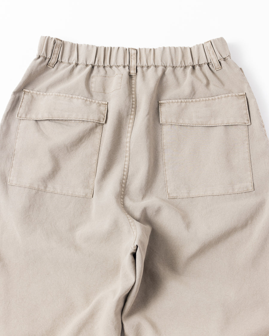 ポリエステル100％ながら、綿のような質感と軽量性を備えた高機能素材を採用。タスラン加工糸によるポリエステルオックスは、シワになりにくく速乾性にも優れています。染色が困難なポリエステルに特殊顔料染めを施すことで、化繊特有の光沢を抑え、ナチュラルで奥行きのある絶妙なフェード感と落ち着いた表情を実現しました。

High-performance polyester oxford with a cotton-like touch, offering quick-dry and wrinkle-resistant benefits. This GRAY BEIGE item features a special pigment dye—a rare process for polyester—achieving a sophisticated, faded texture and a matte finish that perfectly balances technical utility with a natural, lived-in aesthetic.