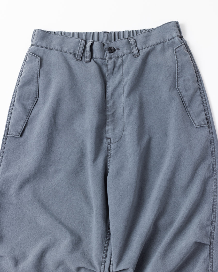 ポリエステル100％ながら、綿のような質感と軽量性を備えた高機能素材を採用。タスラン加工糸によるポリエステルオックスは、シワになりにくく速乾性にも優れています。染色が困難なポリエステルに特殊顔料染めを施すことで、化繊特有の光沢を抑え、ナチュラルで奥行きのある絶妙なフェード感と落ち着いた表情を実現しました。

High-performance polyester oxford with a cotton-like touch, offering quick-dry and wrinkle-resistant benefits. This GRAY BLUE item features a special pigment dye—a rare process for polyester—achieving a sophisticated, faded texture and a matte finish that perfectly balances technical utility with a natural, lived-in aesthetic.