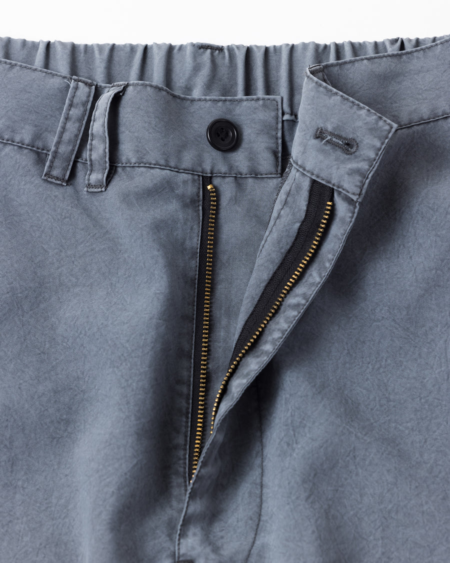 ポリエステル100％ながら、綿のような質感と軽量性を備えた高機能素材を採用。タスラン加工糸によるポリエステルオックスは、シワになりにくく速乾性にも優れています。染色が困難なポリエステルに特殊顔料染めを施すことで、化繊特有の光沢を抑え、ナチュラルで奥行きのある絶妙なフェード感と落ち着いた表情を実現しました。

High-performance polyester oxford with a cotton-like touch, offering quick-dry and wrinkle-resistant benefits. This GRAY BLUE item features a special pigment dye—a rare process for polyester—achieving a sophisticated, faded texture and a matte finish that perfectly balances technical utility with a natural, lived-in aesthetic.