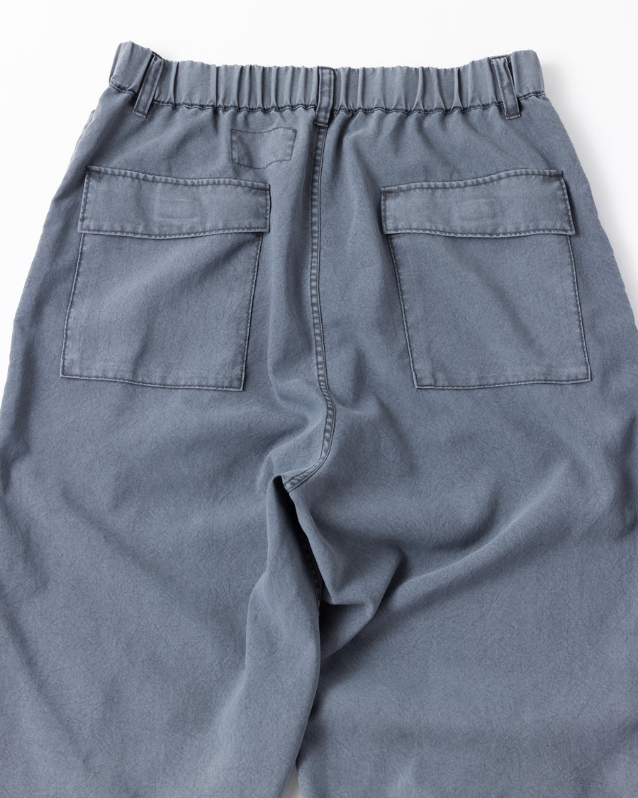 ポリエステル100％ながら、綿のような質感と軽量性を備えた高機能素材を採用。タスラン加工糸によるポリエステルオックスは、シワになりにくく速乾性にも優れています。染色が困難なポリエステルに特殊顔料染めを施すことで、化繊特有の光沢を抑え、ナチュラルで奥行きのある絶妙なフェード感と落ち着いた表情を実現しました。

High-performance polyester oxford with a cotton-like touch, offering quick-dry and wrinkle-resistant benefits. This GRAY BLUE item features a special pigment dye—a rare process for polyester—achieving a sophisticated, faded texture and a matte finish that perfectly balances technical utility with a natural, lived-in aesthetic.