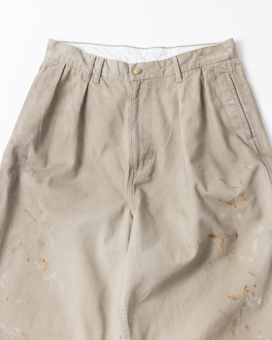 フロントに2タックを施し、ワタリから裾にかけてゆとりを持たせたワイルドなワイドシルエット。裾のドローコードでシルエットの変化も自在に楽しめます。素材には耐久性に優れ、綾織特有の柔らかさを持つ厚手チノクロスを採用。ストーンバイオウォッシュと汚し加工を重ねることで、長年穿き込んだようなリアルな質感と深みのある表情を引き出しました。

Wild, wide-silhouette pants with double-tucked fronts and adjustable hem drawcords. Crafted from durable, soft chino cloth, this BEIGE pair features a stone bio-wash and staining process. This creates an authentic, rugged texture and a deeply weathered look, blending vintage workwear aesthetics with a modern, voluminous fit.