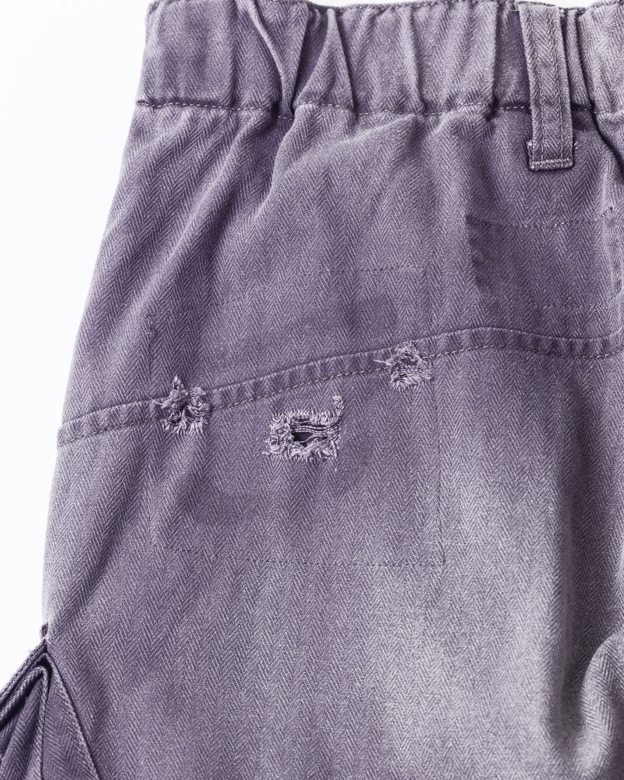 ミリタリートラウザーズを現代的にリファイン。斜めのカーゴポケットが実用的なアクセントを添え、洗練されたテーパードラインが際立ちます。素材には肌馴染みの良い10sヘリンボンを採用。環境に配慮した特殊エイジング・サンフェード加工と随所のリメイクにより、リアリティのある褪色感とヴィンテージな佇まいを表現しました。

Modernized military trousers with a refined tapered fit and slanted cargo pockets. Crafted from soft 10s herringbone, this CHARCPAL pair features special sun-fading and remake details. It achieves an authentic, time-worn vintage character while utilizing eco-conscious processing to minimize environmental impact.