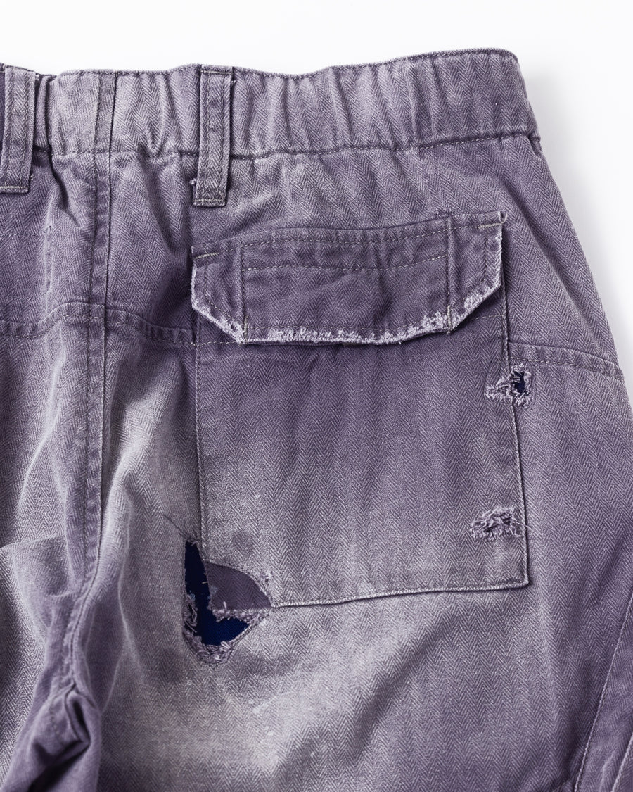 ミリタリートラウザーズを現代的にリファイン。斜めのカーゴポケットが実用的なアクセントを添え、洗練されたテーパードラインが際立ちます。素材には肌馴染みの良い10sヘリンボンを採用。環境に配慮した特殊エイジング・サンフェード加工と随所のリメイクにより、リアリティのある褪色感とヴィンテージな佇まいを表現しました。

Modernized military trousers with a refined tapered fit and slanted cargo pockets. Crafted from soft 10s herringbone, this CHARCPAL pair features special sun-fading and remake details. It achieves an authentic, time-worn vintage character while utilizing eco-conscious processing to minimize environmental impact.