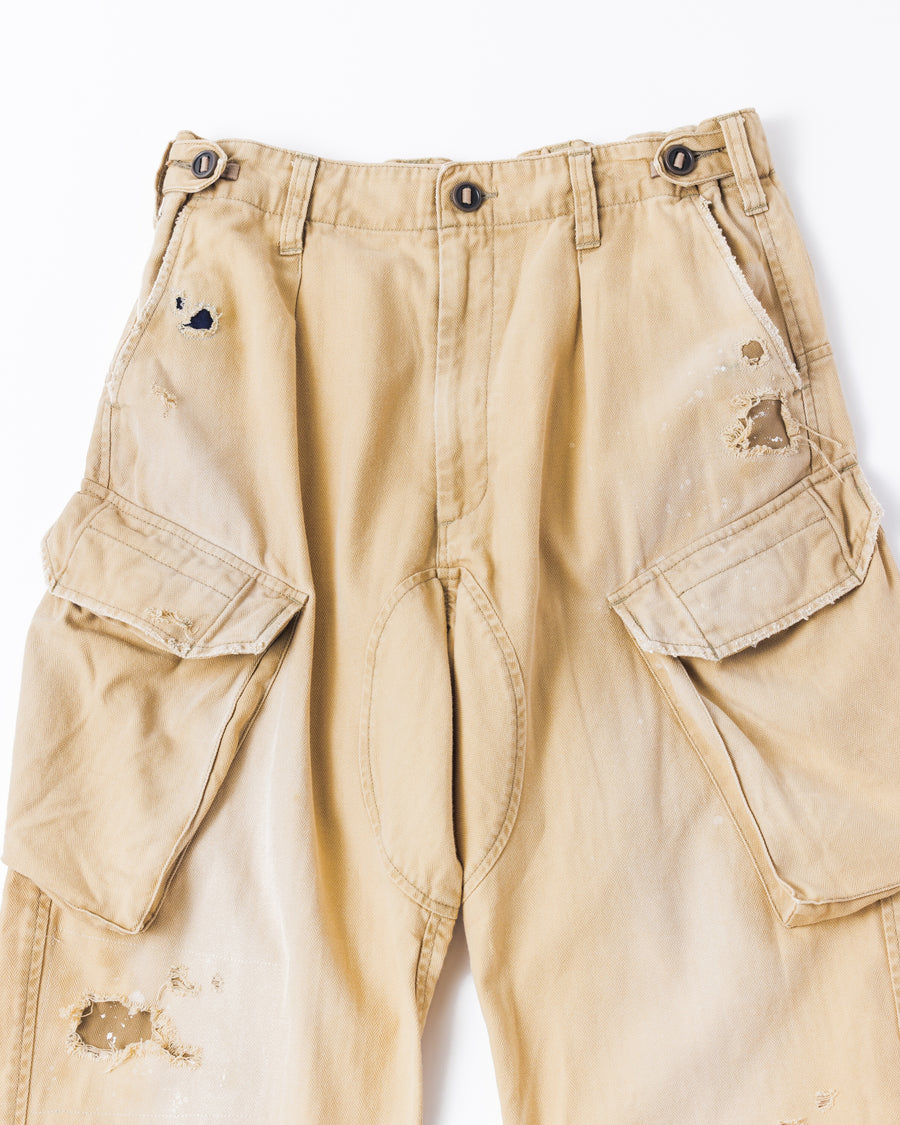 ミリタリートラウザーズを現代的にリファイン。斜めのカーゴポケットが実用的なアクセントを添え、洗練されたテーパードラインが際立ちます。素材には肌馴染みの良い10sヘリンボンを採用。環境に配慮した特殊エイジング・サンフェード加工と随所のリメイクにより、リアリティのある褪色感とヴィンテージな佇まいを表現しました。

Modernized military trousers with a refined tapered fit and slanted cargo pockets. Crafted from soft 10s herringbone, this KHAKI pair features special sun-fading and remake details. It achieves an authentic, time-worn vintage character while utilizing eco-conscious processing to minimize environmental impact.