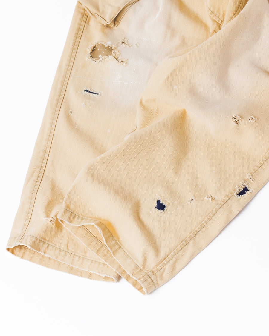 ミリタリートラウザーズを現代的にリファイン。斜めのカーゴポケットが実用的なアクセントを添え、洗練されたテーパードラインが際立ちます。素材には肌馴染みの良い10sヘリンボンを採用。環境に配慮した特殊エイジング・サンフェード加工と随所のリメイクにより、リアリティのある褪色感とヴィンテージな佇まいを表現しました。

Modernized military trousers with a refined tapered fit and slanted cargo pockets. Crafted from soft 10s herringbone, this KHAKI pair features special sun-fading and remake details. It achieves an authentic, time-worn vintage character while utilizing eco-conscious processing to minimize environmental impact.