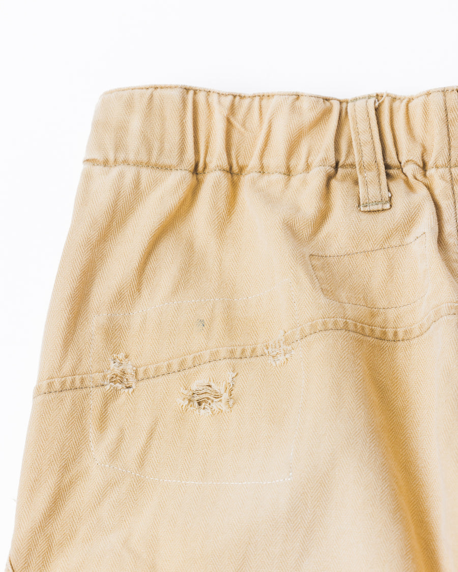 ミリタリートラウザーズを現代的にリファイン。斜めのカーゴポケットが実用的なアクセントを添え、洗練されたテーパードラインが際立ちます。素材には肌馴染みの良い10sヘリンボンを採用。環境に配慮した特殊エイジング・サンフェード加工と随所のリメイクにより、リアリティのある褪色感とヴィンテージな佇まいを表現しました。

Modernized military trousers with a refined tapered fit and slanted cargo pockets. Crafted from soft 10s herringbone, this KHAKI pair features special sun-fading and remake details. It achieves an authentic, time-worn vintage character while utilizing eco-conscious processing to minimize environmental impact.