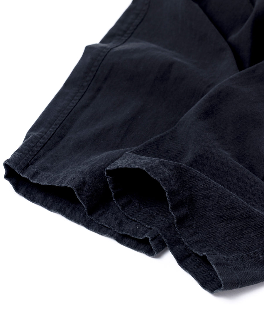 ミリタリートラウザーズをベースに、シルエットを現代的にリファイン。印象的な斜めのカーゴポケットが、立体感と実用性を両立させています。裾にかけて緩やかに絞られたテーパードラインにより、無骨ながらも洗練された印象に。素材には肌馴染みの良い10sヘリンボンを採用し、ストーンバイオウォッシュで柔らかな風合いとこなれ感を引き出しました。

Military trousers refined with a modern tapered silhouette. The distinctive slanted cargo pockets offer both practical utility and a structured look. Crafted from soft, classic 10s herringbone, this BLACK pair has been treated with a stone bio-wash, providing a comfortable, worn-in texture and a sophisticated take on rugged style.