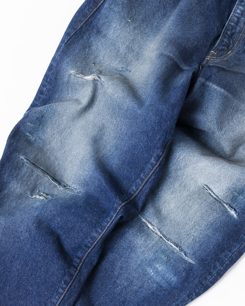 85年製Levi's 550をベースにしたワイドテーパード。80年代のフラットな質感を再現した14ozハチマルデニムを使用し、空紡糸特有のドライなタッチが特徴です。中濃色のエイジング、リアルなリペア、仕上げの汚し加工により、ハードなアタリと奥行きのあるユーズド感を表現した、ヴィンテージ顔負けの一着です。Wide tapered jeans inspired by the '85 Levi's 550. Made from 14oz "Hachimaru" denim, it features a flat look and dry touch. With heavy aging, authentic repairs, and a "dirty" finish, it achieves a deep, realistic vintage character.