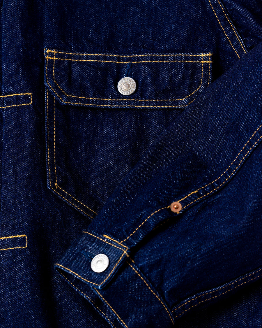 507XX（2ndタイプ）をベースに、現代的なシルエットへとリファインしたデニムジャケット。素材には7×10のナチュラルムラ糸を使用した11.5ozデニムを採用しました。最大の特徴は、絶妙な厚みと調和する自然なムラ感。ワンウォッシュで仕上げることで、オーセンティックなヴィンテージの雰囲気を漂わせつつ、洗練された佇まいを表現した一着です。A refined denim jacket based on the iconic 507XX (2nd type) with a modern silhouette. Crafted from 11.5oz denim using 7x10 natural slub yarns, it offers a perfect balance of weight and texture. This INDIGO piece features a one-wash finish, highlighting the fabric's authentic vintage character and subtle irregularities for a sophisticated yet