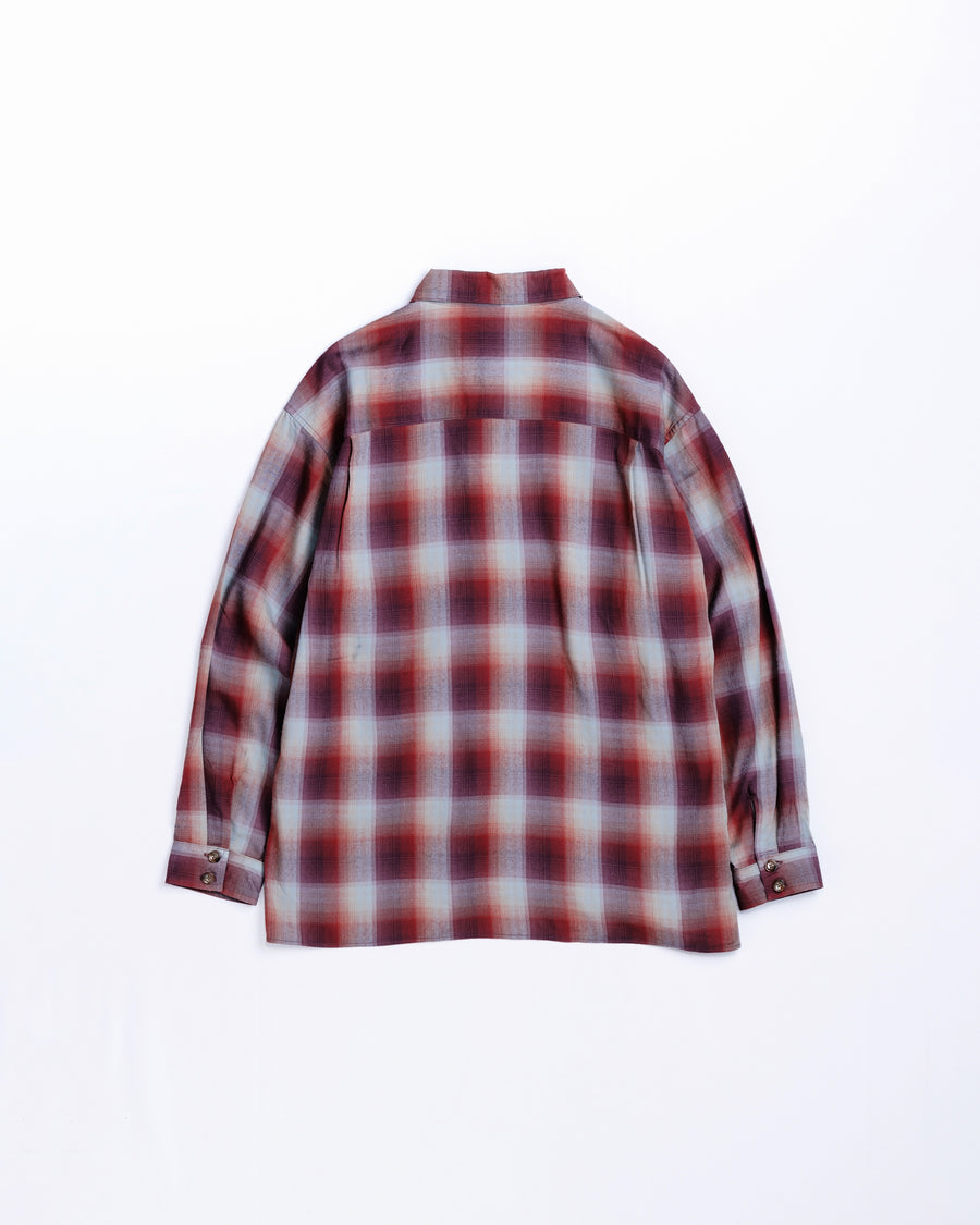 オンブレチェック柄が目を惹くオープンカラーシャツ。生地が持つ自然なドレープ感を活かし、リラックス感のあるゆとりを持たせたシルエットに仕上げました。素材にはタテ・ヨコ共にレーヨン糸を使用したレーヨンチェックを採用。非常に優れた落ち感と、袖を通した瞬間に感じる滑らかで心地よい肌触りが、上質なリラックススタイルを演出します。

An open-collar shirt featuring a classic ombre check pattern. The relaxed silhouette highlights the natural drape and fluid movement of the fabric. Crafted from a high-quality rayon check weave, this RED CHECK piece is characterized by its exceptional softness and smooth touch, offering a sophisticated look with an effortlessly comfortable feel.