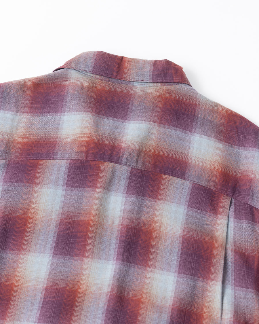 オンブレチェック柄が目を惹くオープンカラーシャツ。生地が持つ自然なドレープ感を活かし、リラックス感のあるゆとりを持たせたシルエットに仕上げました。素材にはタテ・ヨコ共にレーヨン糸を使用したレーヨンチェックを採用。非常に優れた落ち感と、袖を通した瞬間に感じる滑らかで心地よい肌触りが、上質なリラックススタイルを演出します。

An open-collar shirt featuring a classic ombre check pattern. The relaxed silhouette highlights the natural drape and fluid movement of the fabric. Crafted from a high-quality rayon check weave, this RED CHECK piece is characterized by its exceptional softness and smooth touch, offering a sophisticated look with an effortlessly comfortable feel.