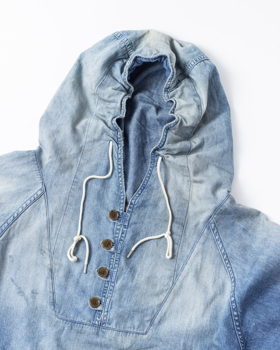 フード口のボタンの開閉により、首まわりのニュアンスを変えて楽しめる一着。素材には、経糸にコットンムラ糸、緯糸に綿麻混紡糸を使用した綿麻6ozデニムを採用しました。シャープなムラ感とリネン混ならではの粗野な風合いが、ヴィンテージの魅力を引き立てます。エイジング加工を施すことで、全体にリアリティのあるアタリ感を出し、長年着込んだような深みのある表情に仕上げました。A versatile piece featuring adjustable hood buttons to create a clean or relaxed neckline. Crafted from 6oz cotton-linen denim, the fabric combines sharp slub textures with a rustic linen feel for an authentic vintage character. Treated with an aging process to create realistic wear and fade, this INDIGO garment offers a sophisti