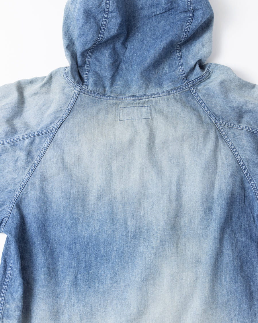 フード口のボタンの開閉により、首まわりのニュアンスを変えて楽しめる一着。素材には、経糸にコットンムラ糸、緯糸に綿麻混紡糸を使用した綿麻6ozデニムを採用しました。シャープなムラ感とリネン混ならではの粗野な風合いが、ヴィンテージの魅力を引き立てます。エイジング加工を施すことで、全体にリアリティのあるアタリ感を出し、長年着込んだような深みのある表情に仕上げました。A versatile piece featuring adjustable hood buttons to create a clean or relaxed neckline. Crafted from 6oz cotton-linen denim, the fabric combines sharp slub textures with a rustic linen feel for an authentic vintage character. Treated with an aging process to create realistic wear and fade, this INDIGO garment offers a sophisti