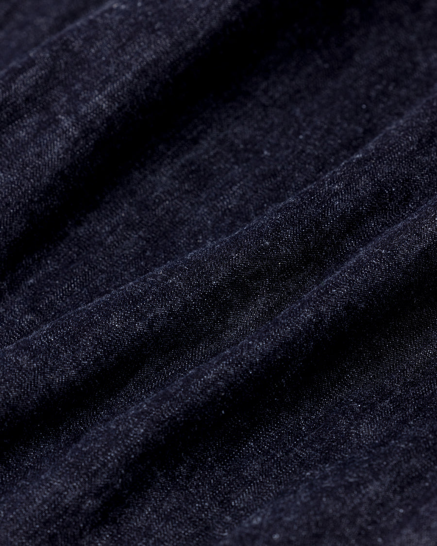 フード口のボタンの開閉により、首まわりのニュアンスを変えて楽しめる一着。素材には、経糸にコットンムラ糸、緯糸に綿麻混紡糸を使用した綿麻6ozデニムを採用しました。シャープなムラ感とリネン混ならではの粗野な風合いが、ヴィンテージの魅力を引き立てます。バイオウォッシュ加工を施すことで、使い始めから体に馴染む柔らかな質感に仕上げました。

A versatile piece featuring adjustable hood buttons to create a clean or relaxed neckline. Crafted from 6oz cotton-linen denim, the fabric combines sharp slub textures with the rustic feel of linen for an authentic vintage character. Treated with a bio-wash process, this INDIGO garment offers a soft, lived-in feel from the very first wear.