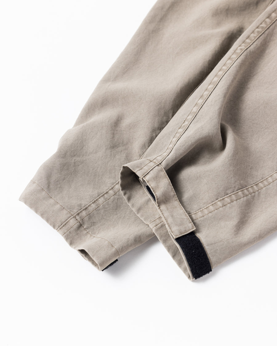 ポリエステル100％でありながら、綿のような質感と軽量性を備えた高機能な一着。タスラン加工糸を使用したポリエステルオックスを採用し、シワになりにくく速乾性に優れたイージーケア性を実現しました。本来染色が困難な素材に特殊顔料染めを施すことで、化繊特有の光沢を抑えた、ナチュラルで奥行きのある絶妙なフェード感を表現しています。

A high-performance piece crafted from polyester oxford, offering a cotton-like touch with lightweight, quick-dry, and wrinkle-resistant properties. This GRAY BEIGE item features a special pigment dye—a rare process for polyester—achieving a sophisticated, faded texture and a matte finish that defies its synthetic origins.