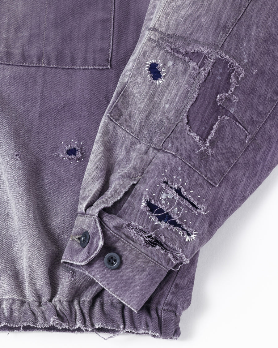 ミリタリーのシャツジャケットを現代的シルエットに更新。裾のドローコードでスタイルに合わせた変化を楽しめます。素材には肌馴染みの良い10sヘリンボンを採用。環境に配慮した特殊エイジング・サンフェード加工とダメージ加工を施すことで、クラシカルな生地にリアリティのある褪色感とヴィンテージライクな佇まいを表現しました。

A modern military shirt jacket with hem drawcords for an adjustable silhouette. Crafted from soft 10s herringbone, this CHARCOAL piece undergoes a special sun-fade and damage process. It achieves a realistic, time-worn vintage look with authentic distressing while minimizing environmental impact through eco-conscious processing.