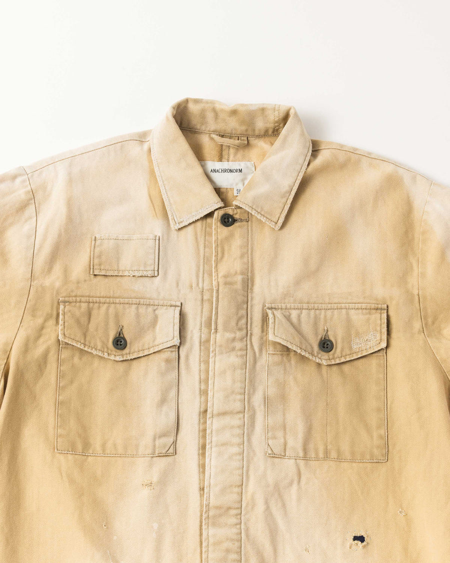 ミリタリーのシャツジャケットを現代的シルエットに更新。裾のドローコードでスタイルに合わせた変化を楽しめます。素材には肌馴染みの良い10sヘリンボンを採用。環境に配慮した特殊エイジング・サンフェード加工とダメージ加工を施すことで、クラシカルな生地にリアリティのある褪色感とヴィンテージライクな佇まいを表現しました。

A modern military shirt jacket with hem drawcords for an adjustable silhouette. Crafted from soft 10s herringbone, this KHAKI piece undergoes a special sun-fade and damage process. It achieves a realistic, time-worn vintage look with authentic distressing while minimizing environmental impact through eco-conscious processing.