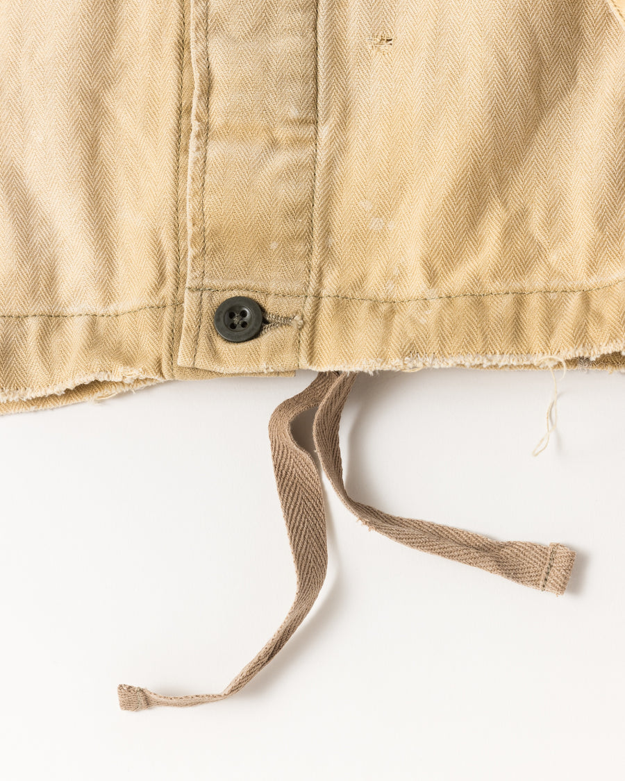 ミリタリーのシャツジャケットを現代的シルエットに更新。裾のドローコードでスタイルに合わせた変化を楽しめます。素材には肌馴染みの良い10sヘリンボンを採用。環境に配慮した特殊エイジング・サンフェード加工とダメージ加工を施すことで、クラシカルな生地にリアリティのある褪色感とヴィンテージライクな佇まいを表現しました。

A modern military shirt jacket with hem drawcords for an adjustable silhouette. Crafted from soft 10s herringbone, this KHAKI piece undergoes a special sun-fade and damage process. It achieves a realistic, time-worn vintage look with authentic distressing while minimizing environmental impact through eco-conscious processing.