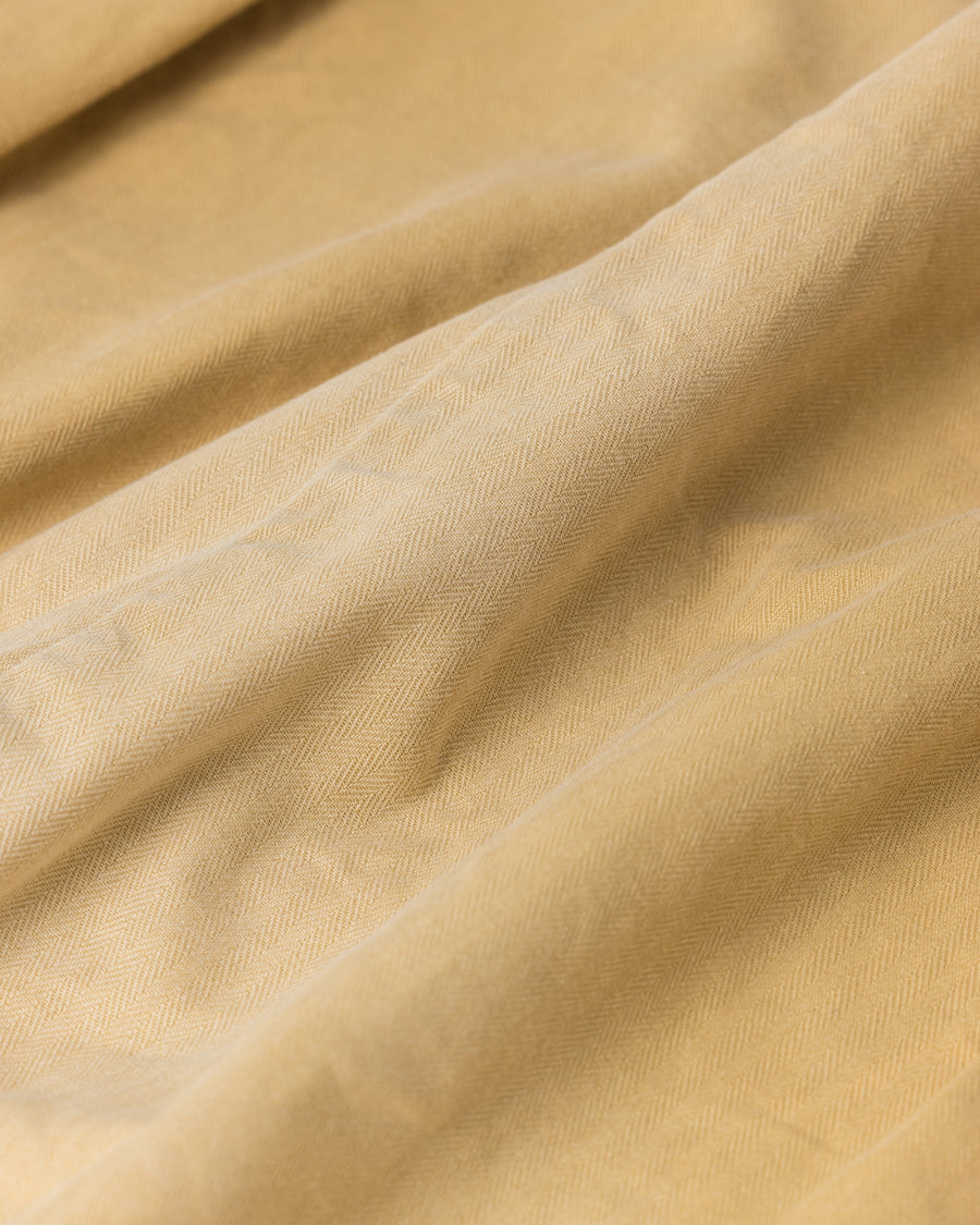 ミリタリーのシャツジャケットを現代的シルエットに更新。裾のドローコードでスタイルに合わせた変化を楽しめます。素材には肌馴染みの良い10sヘリンボンを採用。環境に配慮した特殊エイジング・サンフェード加工とダメージ加工を施すことで、クラシカルな生地にリアリティのある褪色感とヴィンテージライクな佇まいを表現しました。

A modern military shirt jacket with hem drawcords for an adjustable silhouette. Crafted from soft 10s herringbone, this KHAKI piece undergoes a special sun-fade and damage process. It achieves a realistic, time-worn vintage look with authentic distressing while minimizing environmental impact through eco-conscious processing.