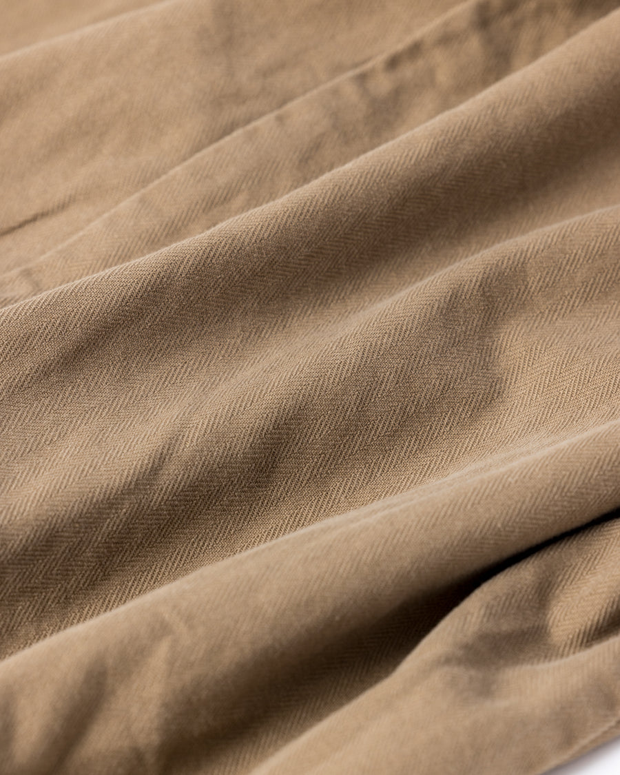 ミリタリーのシャツジャケットを現代的シルエットに更新。裾のドローコードで着丈のニュアンスを自在に調整可能です。素材には、やや甘織りで肌馴染みの良い10sヘリンボンを採用。ストーンバイオウォッシュを施すことで、クラシカルな生地感に柔らかな風合いとこなれ感をプラスした、着回し力の高い一着に仕上げました。

A modern update to the classic military shirt jacket, featuring hem drawcords for an adjustable silhouette. Crafted from 10s herringbone, slightly loose-knitted for a soft, comfortable touch. This KHAKI piece has been treated with a stone bio-wash, giving the traditional weave a natural, worn-in texture and a sophisticated casual feel.