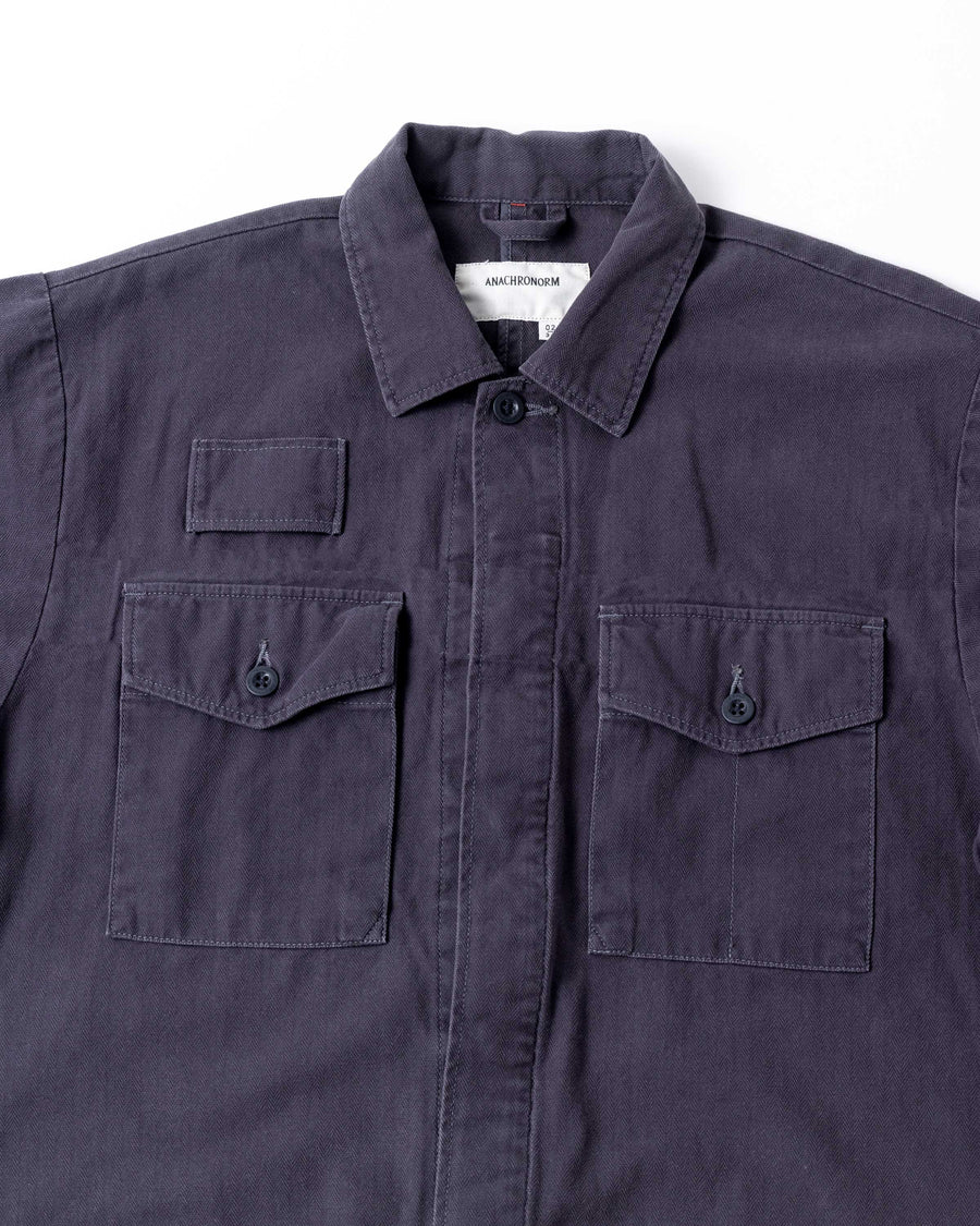 ミリタリーのシャツジャケットを現代的シルエットに更新。裾のドローコードで着丈のニュアンスを自在に調整可能です。素材には、やや甘織りで肌馴染みの良い10sヘリンボンを採用。ストーンバイオウォッシュを施すことで、クラシカルな生地感に柔らかな風合いとこなれ感をプラスした、着回し力の高い一着に仕上げました。

A modern update to the classic military shirt jacket, featuring hem drawcords for an adjustable silhouette. Crafted from 10s herringbone, slightly loose-knitted for a soft, comfortable touch. This CHARCOAL piece has been treated with a stone bio-wash, giving the traditional weave a natural, worn-in texture and a sophisticated casual feel.