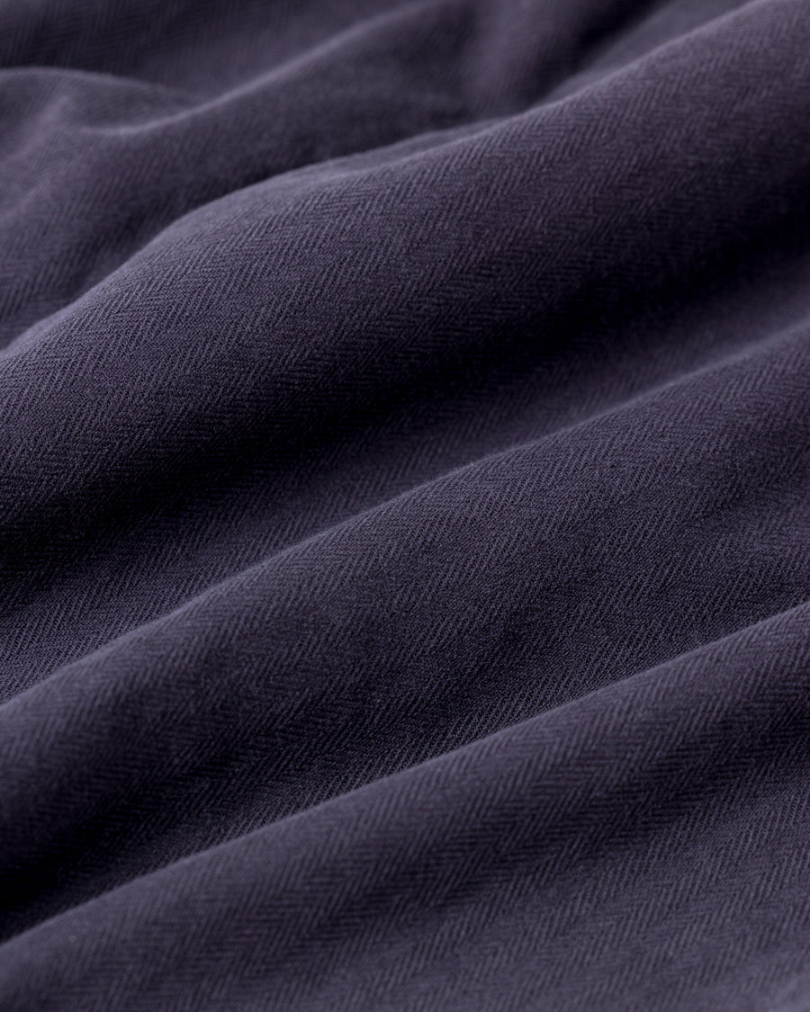 ミリタリーのシャツジャケットを現代的シルエットに更新。裾のドローコードで着丈のニュアンスを自在に調整可能です。素材には、やや甘織りで肌馴染みの良い10sヘリンボンを採用。ストーンバイオウォッシュを施すことで、クラシカルな生地感に柔らかな風合いとこなれ感をプラスした、着回し力の高い一着に仕上げました。

A modern update to the classic military shirt jacket, featuring hem drawcords for an adjustable silhouette. Crafted from 10s herringbone, slightly loose-knitted for a soft, comfortable touch. This CHARCOAL piece has been treated with a stone bio-wash, giving the traditional weave a natural, worn-in texture and a sophisticated casual feel.