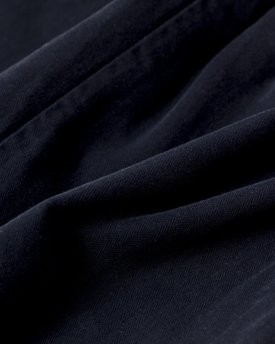 ミリタリーのシャツジャケットを現代的シルエットに更新。裾のドローコードで着丈のニュアンスを自在に調整可能です。素材には、やや甘織りで肌馴染みの良い10sヘリンボンを採用。ストーンバイオウォッシュを施すことで、クラシカルな生地感に柔らかな風合いとこなれ感をプラスした、着回し力の高い一着に仕上げました。

A modern update to the classic military shirt jacket, featuring hem drawcords for an adjustable silhouette. Crafted from 10s herringbone, slightly loose-knitted for a soft, comfortable touch. This BLACK piece has been treated with a stone bio-wash, giving the traditional weave a natural, worn-in texture and a sophisticated casual feel.