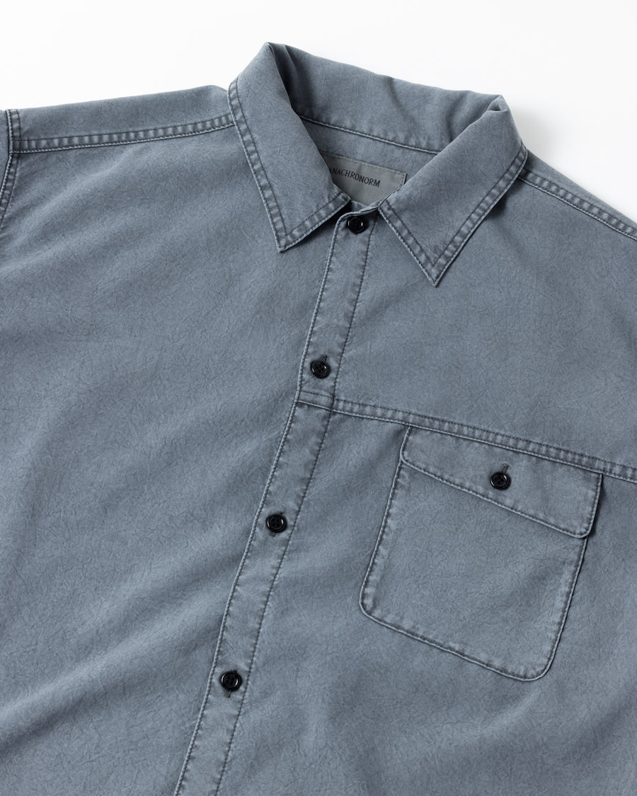 ポリエステル100％ながら、綿のような質感と軽量性を備えた高機能素材を採用。タスラン加工糸を使用したポリエステルオックスは、シワになりにくく速乾性にも優れています。本来染色が困難な素材に特殊顔料染めを施すことで、化繊特有の光沢を抑え、ナチュラルで奥行きのある絶妙なフェード感と落ち着いた表情を実現しました。

A high-performance piece crafted from polyester oxford, offering a cotton-like touch with quick-dry and wrinkle-resistant benefits. This GRAY BEIGE item features a special pigment dye—a rare process for polyester—achieving a sophisticated, faded texture and a matte finish that perfectly balances technical utility with a natural, lived-in aesthetic.