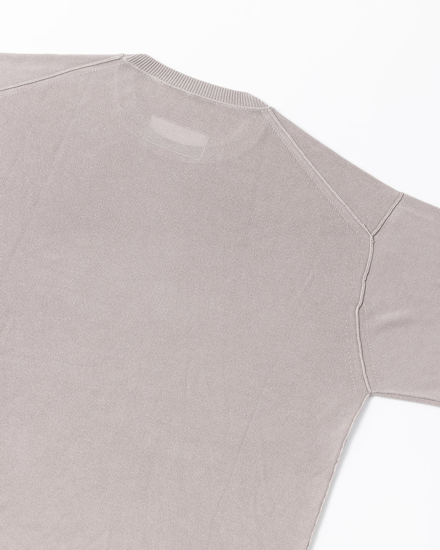 ディテールを極限まで削ぎ落とし、着心地とシルエットを追求したニットTシャツ。気候変化に対応する新たなアプローチとして、軽量で吸水・放湿性に優れた竹（バンブー）素材を採用しました。滑らかでとろみのある肌触りと、袖を通した瞬間に感じる清涼感は格別です。家庭洗濯も可能で、日常に圧倒的な心地よさを提供します。

A minimalist knit T-shirt focused entirely on fit and comfort. Crafted from bamboo yarn, this lightweight, durable material offers exceptional moisture absorption and a refreshing cool-to-the-touch feel. This LIGHT BEIGE piece features a silky, fluid drape that provides overwhelming comfort, perfect for changing climates, and is conveniently home-washable.