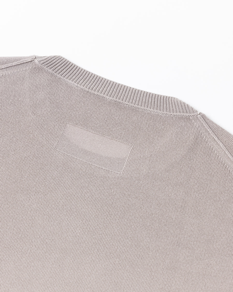 ディテールを極限まで削ぎ落とし、着心地とシルエットを追求したニットTシャツ。気候変化に対応する新たなアプローチとして、軽量で吸水・放湿性に優れた竹（バンブー）素材を採用しました。滑らかでとろみのある肌触りと、袖を通した瞬間に感じる清涼感は格別です。家庭洗濯も可能で、日常に圧倒的な心地よさを提供します。

A minimalist knit T-shirt focused entirely on fit and comfort. Crafted from bamboo yarn, this lightweight, durable material offers exceptional moisture absorption and a refreshing cool-to-the-touch feel. This LIGHT BEIGE piece features a silky, fluid drape that provides overwhelming comfort, perfect for changing climates, and is conveniently home-washable.