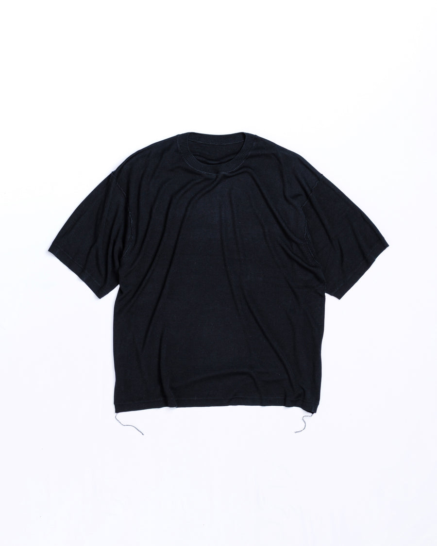 ディテールを極限まで削ぎ落とし、着心地とシルエットを追求したニットTシャツ。気候変化に対応する新たなアプローチとして、軽量で吸水・放湿性に優れた竹（バンブー）素材を採用しました。滑らかでとろみのある肌触りと、袖を通した瞬間に感じる清涼感は格別です。家庭洗濯も可能で、日常に圧倒的な心地よさを提供します。

A minimalist knit T-shirt focused entirely on fit and comfort. Crafted from bamboo yarn, this lightweight, durable material offers exceptional moisture absorption and a refreshing cool-to-the-touch feel. This BLACK piece features a silky, fluid drape that provides overwhelming comfort, perfect for changing climates, and is conveniently home-washable.