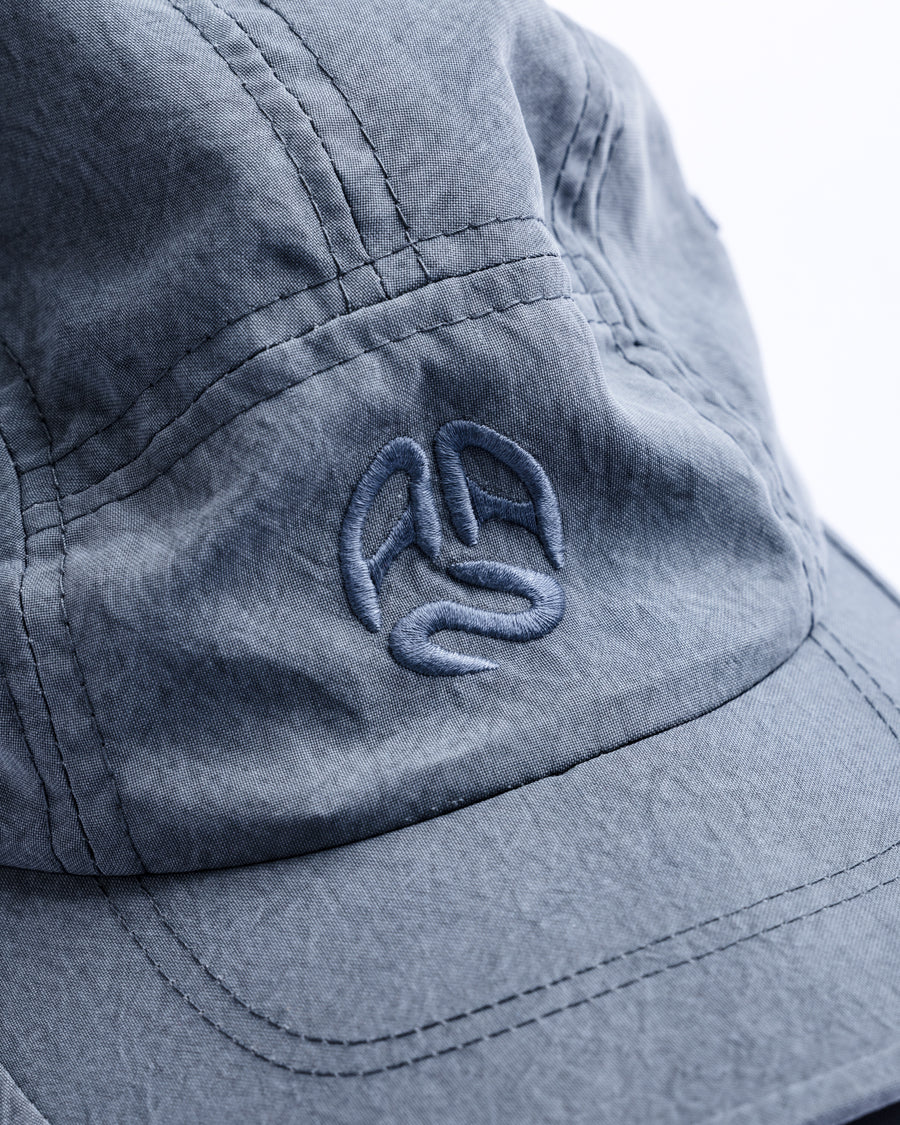 綿のような質感と軽量性を備えた高機能なポリエステルオックスを採用。タスラン加工糸により、シワになりにくく速乾性に優れたイージーケア性を実現しました。染色が困難なポリエステルに特殊顔料染めを施すことで、光沢を抑えたナチュラルで奥行きのある表情に。裏地にはサステナブルなリサイクルメッシュを使用し、快適な着用感にもこだわりました。

High-performance polyester oxford with a cotton-like touch, offering quick-dry and wrinkle-resistant benefits. This GRAY BLUE piece features a special pigment dye for a matte, faded texture, defying its synthetic roots. Lined with eco-friendly recycled mesh, it ensures breathability while maintaining a sophisticated, natural aesthetic.