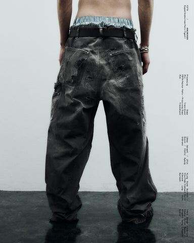 中目黒の「FIFTH GENERAL STORE」とのコラボモデル。同店のダブルニーパンツをベースに、ANACHRONORMが贅沢なリメイクを施しました。高密度ダック地に、独自のG-Brown硫化染めと重層的なバイオ加工、サンフェード、全面の千鳥ステッチ補修を敢行。職人の高度な技術を惜しみなく注ぎ込み、ワークウェアを超越した圧倒的な奥行きとリアリティを追求した究極の一本です。
A collaboration with Nakameguro’s FIFTH GENERAL STORE. Based on their double-knee pants, ANACHRONORM applied luxury distressing, custom G-Brown sulfur dyeing, and meticulous zigzag stitch repairs. It features profound depth and a realistic sun-faded patina, showcasing elite craftsmanship.