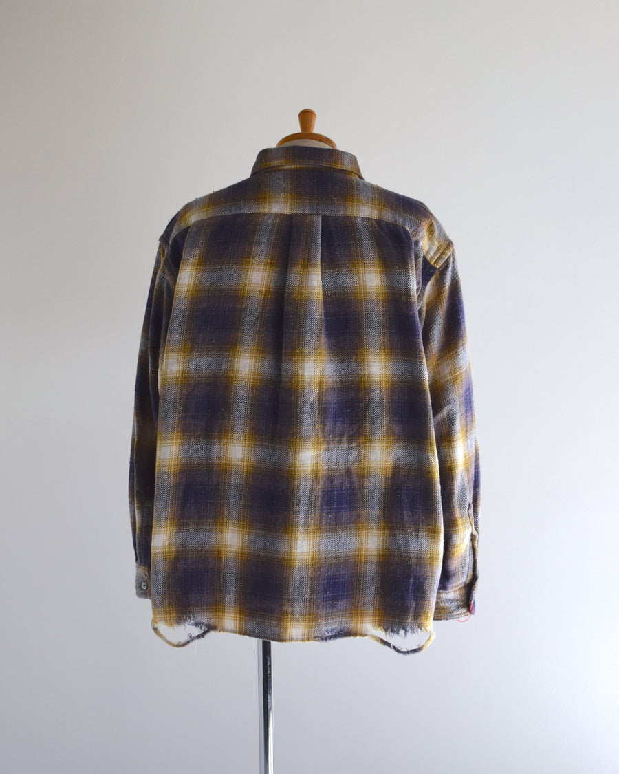 ANACHRONORMで以前リリースしていたリサイズシャツのシルエットをリファインした、ワイドシルエットシャツです。
随所に施された細かなステッチワークやダメージ加工にもご注目ください。
生地はリサイクルコットンとポリエステルを混紡したT/Cネップチェックで、起毛によるネップの風合いとメランジ染めの独特なムラ感が特徴です。
使用している生地はバランス別注でパープルとイエローのチェック柄。
サスティナブルブリーチ加工とダメージ加工を施しており、環境に配慮しつつPURPLE×BLACKカラーで仕上げています。