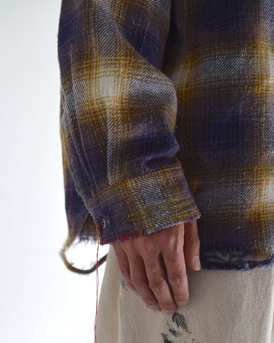 ANACHRONORMで以前リリースしていたリサイズシャツのシルエットをリファインした、ワイドシルエットシャツです。
随所に施された細かなステッチワークやダメージ加工にもご注目ください。
生地はリサイクルコットンとポリエステルを混紡したT/Cネップチェックで、起毛によるネップの風合いとメランジ染めの独特なムラ感が特徴です。
使用している生地はバランス別注でパープルとイエローのチェック柄。
サスティナブルブリーチ加工とダメージ加工を施しており、環境に配慮しつつPURPLE×BLACKカラーで仕上げています。