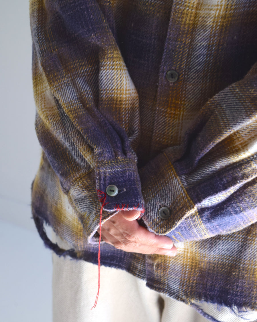 ANACHRONORMで以前リリースしていたリサイズシャツのシルエットをリファインした、ワイドシルエットシャツです。
随所に施された細かなステッチワークやダメージ加工にもご注目ください。
生地はリサイクルコットンとポリエステルを混紡したT/Cネップチェックで、起毛によるネップの風合いとメランジ染めの独特なムラ感が特徴です。
使用している生地はバランス別注でパープルとイエローのチェック柄。
サスティナブルブリーチ加工とダメージ加工を施しており、環境に配慮しつつPURPLE×BLACKカラーで仕上げています。