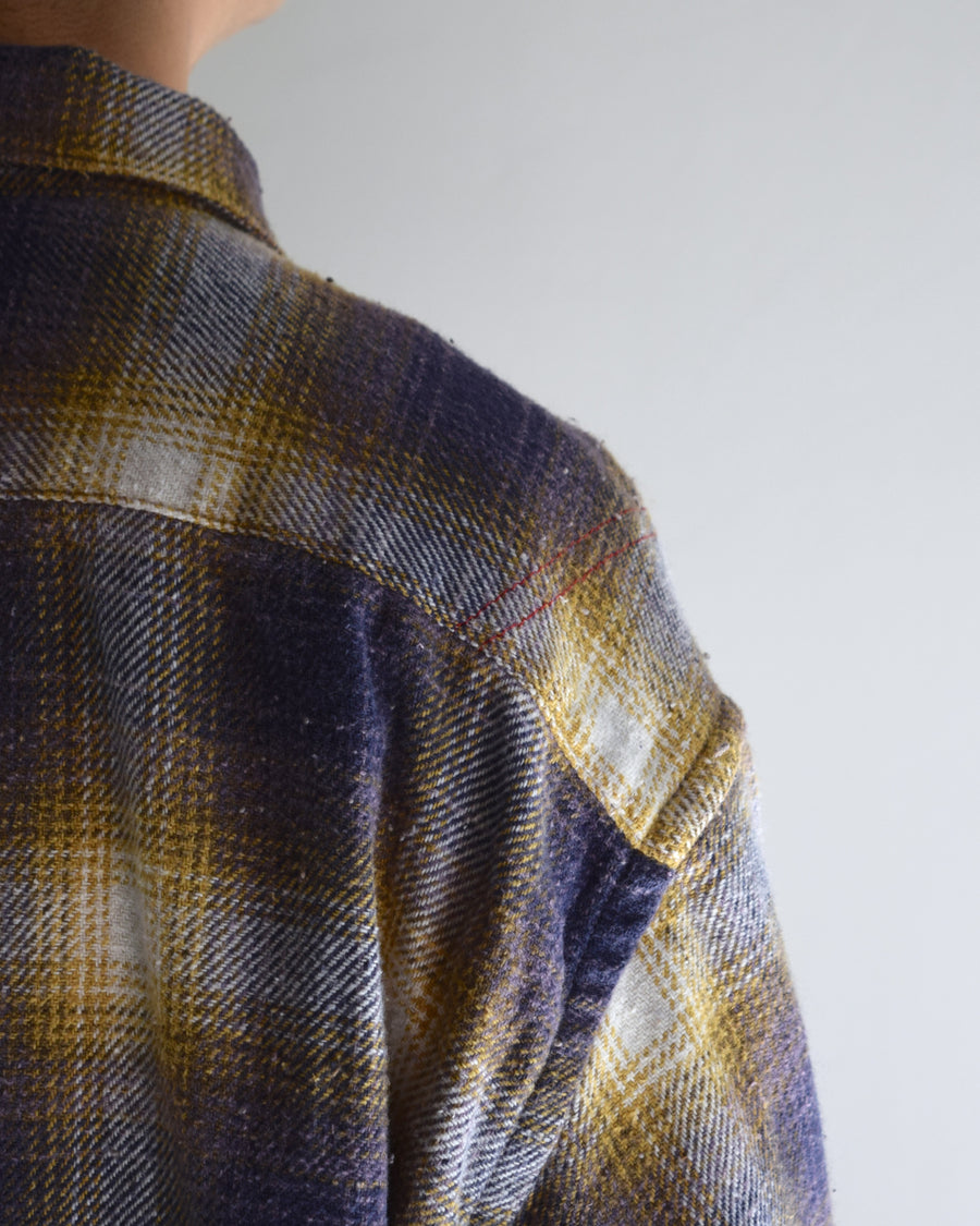 ANACHRONORMで以前リリースしていたリサイズシャツのシルエットをリファインした、ワイドシルエットシャツです。
随所に施された細かなステッチワークやダメージ加工にもご注目ください。
生地はリサイクルコットンとポリエステルを混紡したT/Cネップチェックで、起毛によるネップの風合いとメランジ染めの独特なムラ感が特徴です。
使用している生地はバランス別注でパープルとイエローのチェック柄。
サスティナブルブリーチ加工とダメージ加工を施しており、環境に配慮しつつPURPLE×BLACKカラーで仕上げています。