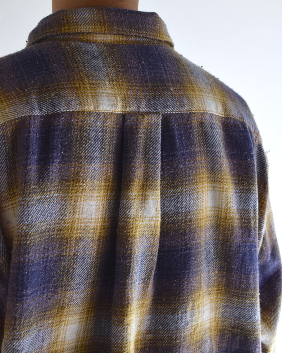 ANACHRONORMで以前リリースしていたリサイズシャツのシルエットをリファインした、ワイドシルエットシャツです。
随所に施された細かなステッチワークやダメージ加工にもご注目ください。
生地はリサイクルコットンとポリエステルを混紡したT/Cネップチェックで、起毛によるネップの風合いとメランジ染めの独特なムラ感が特徴です。
使用している生地はバランス別注でパープルとイエローのチェック柄。
サスティナブルブリーチ加工とダメージ加工を施しており、環境に配慮しつつPURPLE×BLACKカラーで仕上げています。