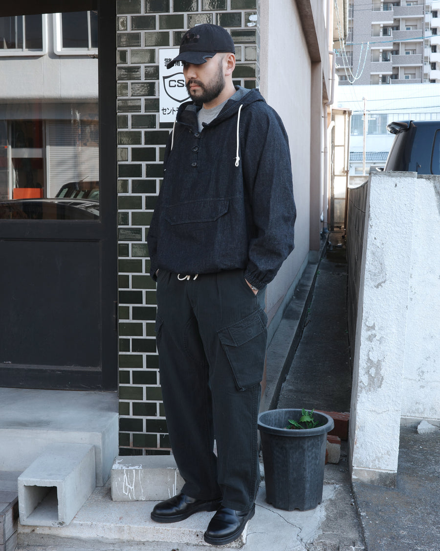 ミリタリートラウザーズをベースに、シルエットを現代的にリファイン。印象的な斜めのカーゴポケットが、立体感と実用性を両立させています。裾にかけて緩やかに絞られたテーパードラインにより、無骨ながらも洗練された印象に。素材には肌馴染みの良い10sヘリンボンを採用し、ストーンバイオウォッシュで柔らかな風合いとこなれ感を引き出しました。

Military trousers refined with a modern tapered silhouette. The distinctive slanted cargo pockets offer both practical utility and a structured look. Crafted from soft, classic 10s herringbone, this BLACK pair has been treated with a stone bio-wash, providing a comfortable, worn-in texture and a sophisticated take on rugged style.