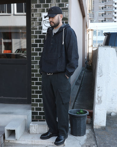 ミリタリートラウザーズをベースに、シルエットを現代的にリファイン。印象的な斜めのカーゴポケットが、立体感と実用性を両立させています。裾にかけて緩やかに絞られたテーパードラインにより、無骨ながらも洗練された印象に。素材には肌馴染みの良い10sヘリンボンを採用し、ストーンバイオウォッシュで柔らかな風合いとこなれ感を引き出しました。

Military trousers refined with a modern tapered silhouette. The distinctive slanted cargo pockets offer both practical utility and a structured look. Crafted from soft, classic 10s herringbone, this BLACK pair has been treated with a stone bio-wash, providing a comfortable, worn-in texture and a sophisticated take on rugged style.