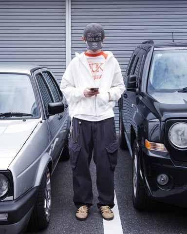 ミリタリートラウザーズをベースに、シルエットを現代的にリファイン。印象的な斜めのカーゴポケットが、立体感と実用性を両立させています。裾にかけて緩やかに絞られたテーパードラインにより、無骨ながらも洗練された印象に。素材には肌馴染みの良い10sヘリンボンを採用し、ストーンバイオウォッシュで柔らかな風合いとこなれ感を引き出しました。

Military trousers refined with a modern tapered silhouette. The distinctive slanted cargo pockets offer both practical utility and a structured look. Crafted from soft, classic 10s herringbone, this CHARCOAL pair has been treated with a stone bio-wash, providing a comfortable, worn-in texture and a sophisticated take on rugged style.