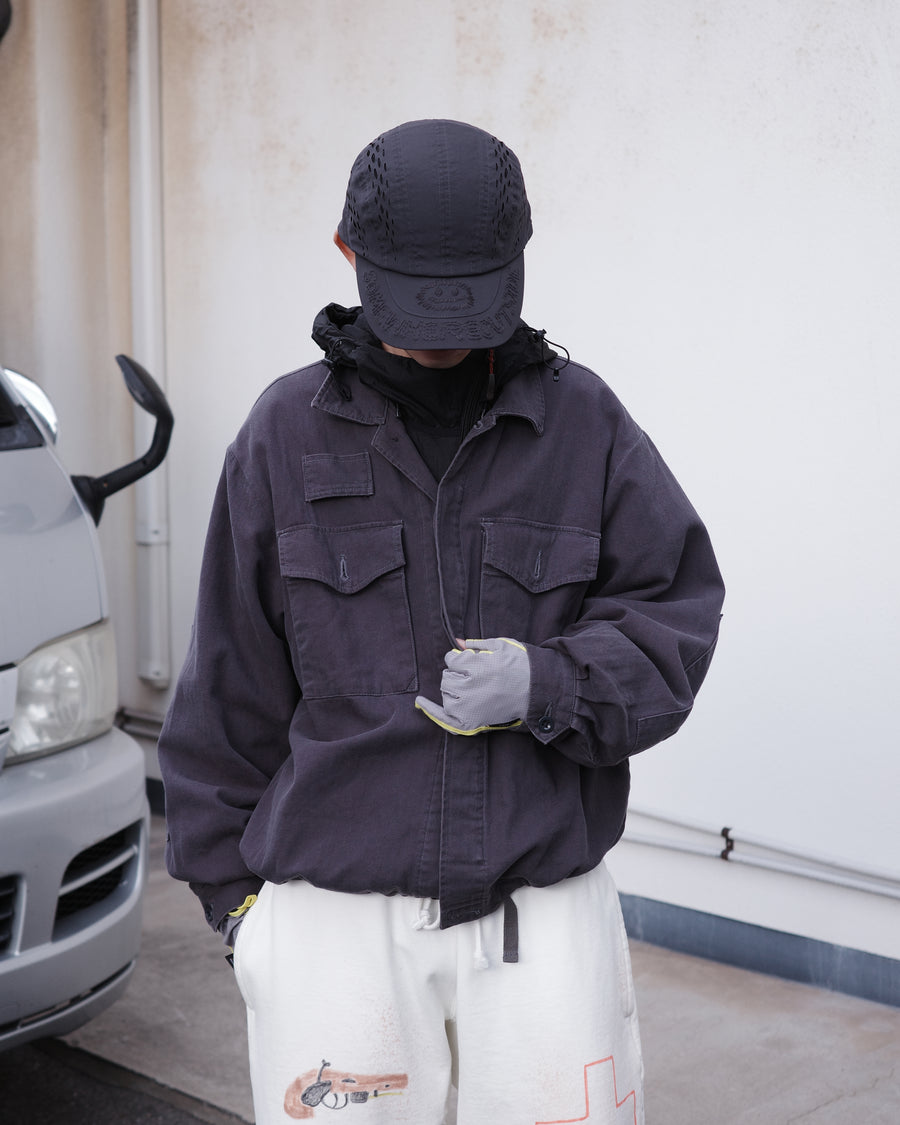 ミリタリーのシャツジャケットを現代的シルエットに更新。裾のドローコードで着丈のニュアンスを自在に調整可能です。素材には、やや甘織りで肌馴染みの良い10sヘリンボンを採用。ストーンバイオウォッシュを施すことで、クラシカルな生地感に柔らかな風合いとこなれ感をプラスした、着回し力の高い一着に仕上げました。

A modern update to the classic military shirt jacket, featuring hem drawcords for an adjustable silhouette. Crafted from 10s herringbone, slightly loose-knitted for a soft, comfortable touch. This CHARCOAL piece has been treated with a stone bio-wash, giving the traditional weave a natural, worn-in texture and a sophisticated casual feel.