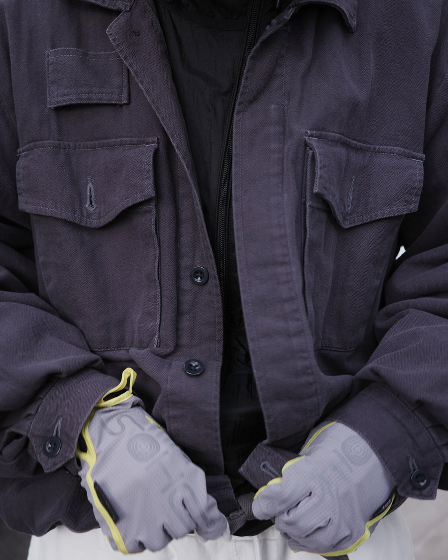 ミリタリーのシャツジャケットを現代的シルエットに更新。裾のドローコードで着丈のニュアンスを自在に調整可能です。素材には、やや甘織りで肌馴染みの良い10sヘリンボンを採用。ストーンバイオウォッシュを施すことで、クラシカルな生地感に柔らかな風合いとこなれ感をプラスした、着回し力の高い一着に仕上げました。

A modern update to the classic military shirt jacket, featuring hem drawcords for an adjustable silhouette. Crafted from 10s herringbone, slightly loose-knitted for a soft, comfortable touch. This CHARCOAL piece has been treated with a stone bio-wash, giving the traditional weave a natural, worn-in texture and a sophisticated casual feel.