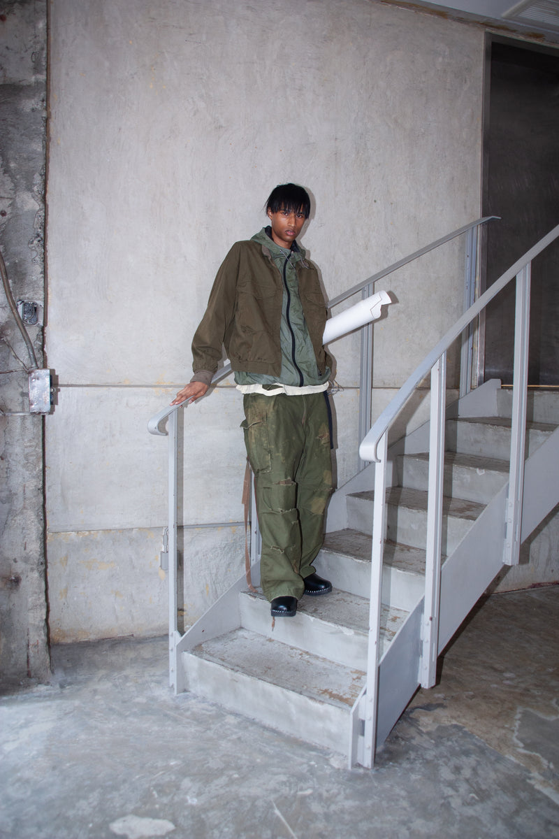 1950年代の希少なフライトジャケットをベースにシルエットを調整し、特徴的なディテールを再現したオリーブカラーのジャケット。
生地にはM1951 ARCTIC OVER PANTSを解析して再現したリプロ素材を使用し、光沢感のあるブライトナイロンを採用。
毛焼きをせずタンブラー仕上げでヴィンテージ感を演出しています。