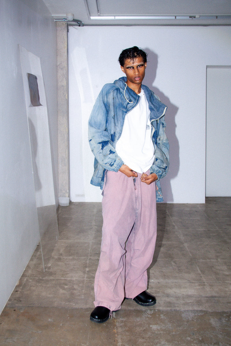 ライトオンスデニムを二重縫製で仕立てたフルジップパーカー。
経糸にジンバブエコットン100％、緯糸に綿麻混紡糸を用いたデニムは、シャープなムラ感と粗野な風合いでヴィンテージ感を演出。
全体にエイジングを施し、ハードダメージと手作業のステッチワークで仕上げたリメイク加工が特徴です。