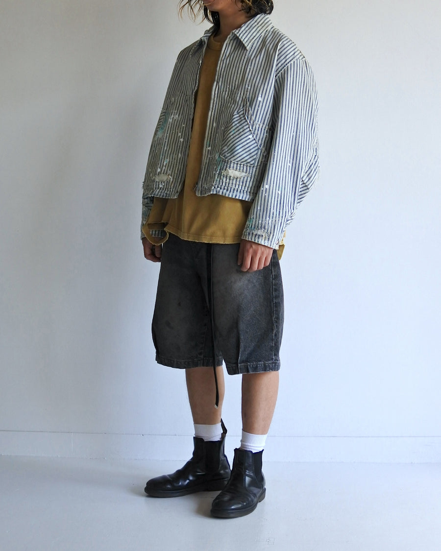 ゆとりある身幅とややクロップド丈でレイヤードを楽しめるデザインにしたヒッコリージャケット。
岡山県製9ozヒッコリーストライプ生地を使用し、ハリのあるしっかりとした風合いが特徴。
全体にエイジングとハードダメージを施し、手作業のステッチ補修とランダムなペンキでリアルな表情に仕上げています。